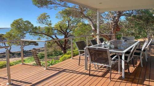 a patio with a table and chairs on a deck at Angasi Is One Of Coffin Bay's Premium Properties - With Free Wifi in Coffin Bay