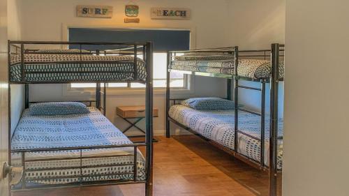 two bunk beds in a room with a hallway at Angasi Is One Of Coffin Bay's Premium Properties - With Free Wifi in Coffin Bay