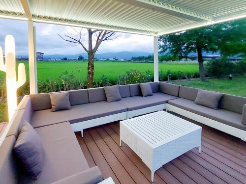 a patio with a couch and a table on a deck at 慢慢三星民宿 ChillaxSanxing B&B in Sanxing