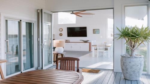 a living room with sliding glass doors and a tv at Lobster Pot II in Coffin Bay