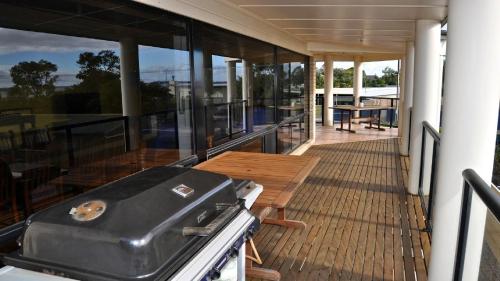a balcony with a grill and a table on a house at Coffin Bay Retreat in Coffin Bay