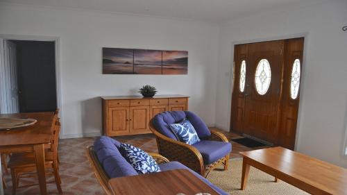 a living room with a couch and chairs and a table at Coffin Bay Retreat in Coffin Bay