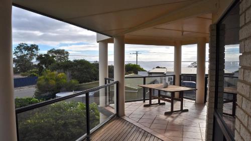 a balcony with a table and a view of the ocean at Coffin Bay Retreat in Coffin Bay