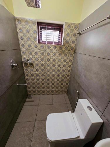 a bathroom with a white toilet and a shower at Tranquil Nest Villa - 4BHK Villa - Entire Villa stay in Wayanad in Kalpetta