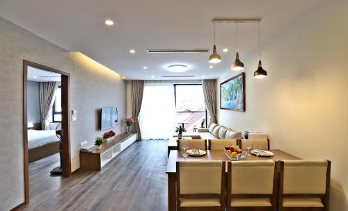 a living room with a dining table and a living room with a bed at Duc Hoang Residence & Hotel West Lake in Hanoi