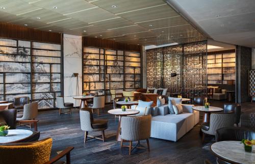 a restaurant with couches and tables and chairs at Renaissance Xi'an Hotel in Xi'an