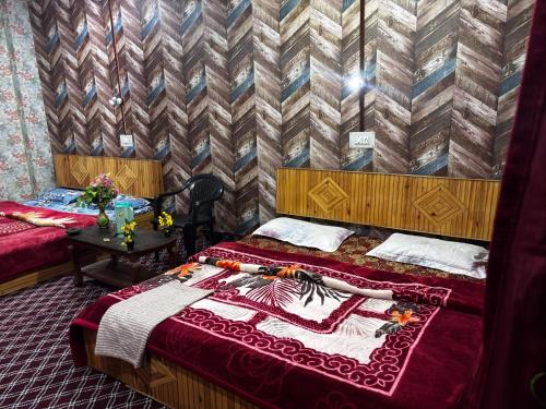 a bedroom with two beds and a table at Aziz Guest House in Srinagar