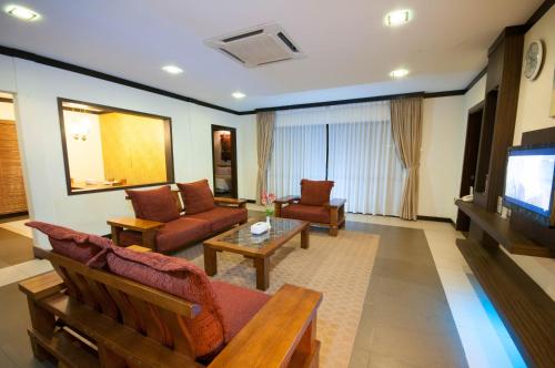 a living room with furniture and a flat screen tv at Hotel Felda Residence Hot Springs in Sungkai