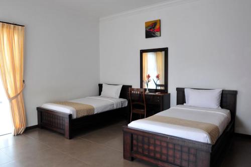 a room with two beds and a mirror at Hotel Felda Residence Hot Springs in Sungkai
