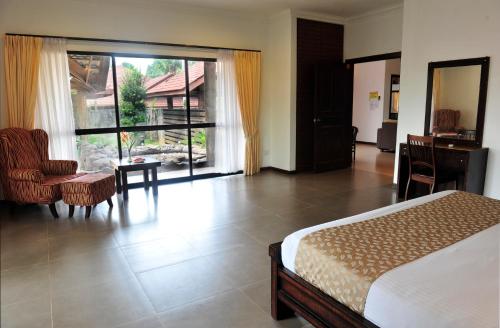 a bedroom with a bed and a room with a window at Hotel Felda Residence Hot Springs in Sungkai