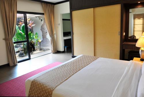 a bedroom with a bed and a large window at Hotel Felda Residence Hot Springs in Sungkai