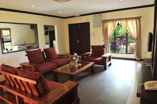 a living room with a couch and a table at Hotel Felda Residence Hot Springs in Sungkai