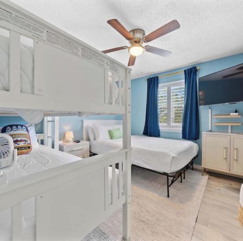 a bedroom with two bunk beds and a ceiling fan at Bayview Condo, Boat Slip & Launch, Pool & Arcade! The Wild Wahoo! in Orange Beach