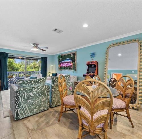 a living room with a couch and chairs and a mirror at Bayview Condo, Boat Slip & Launch, Pool & Arcade! The Wild Wahoo! in Orange Beach