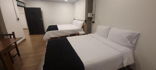 a room with two beds and a table and a desk at Hotel Quinta Bolivar in Bogotá