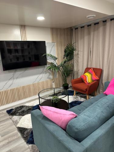 a living room with a blue couch and a chair at Elegant & Stylish Basement Suite- Private Entrance in Winnipeg