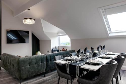 a dining room with a table and a couch at Edgerton Apartments in Huddersfield