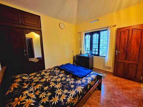a bedroom with a bed and a dresser and a window at Tranquil Nest Villa - 4BHK Villa - Entire Villa stay in Wayanad in Kalpetta
