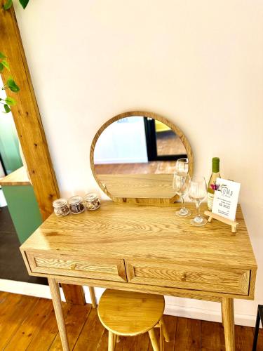 a wooden table with a mirror and wine glasses at LOMA in Hagoshrim