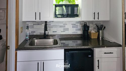 a kitchen with a sink and a microwave at Modern Moose Free Shuttle to SDC in Branson