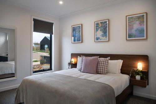 a bedroom with a large bed and a window at Bluestone Haus - stylish home in Daylesford