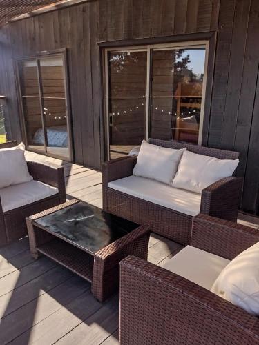 a patio with wicker chairs and a table and windows at La madriguera Matanzas in Navidad