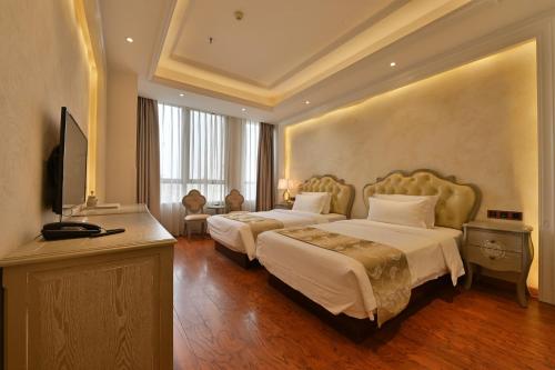 a hotel room with two beds and a television at 成都吾行东方酒店 in Chengdu