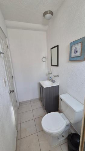 a bathroom with a white toilet and a sink at Marina Diamante Victory in Acapulco