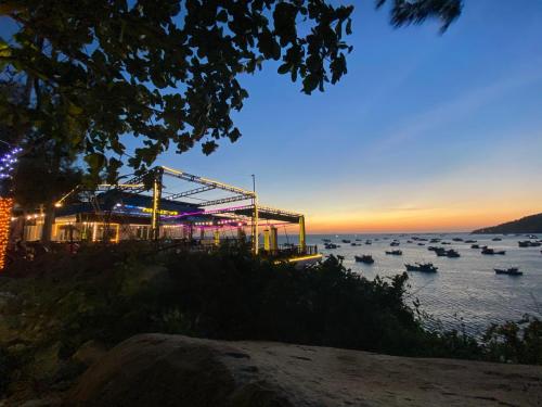 a group of boats in the water at dusk at Coco Bay Hon Son in Lai Sơn