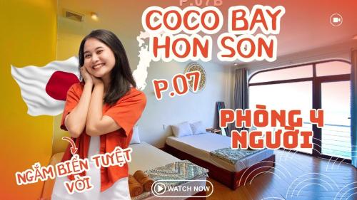a woman standing in front of a room with a bed at Coco Bay Hon Son in Lai Sơn