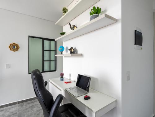 an office with a white desk with a laptop on it at Apartahotelquimbaya in Quimbaya