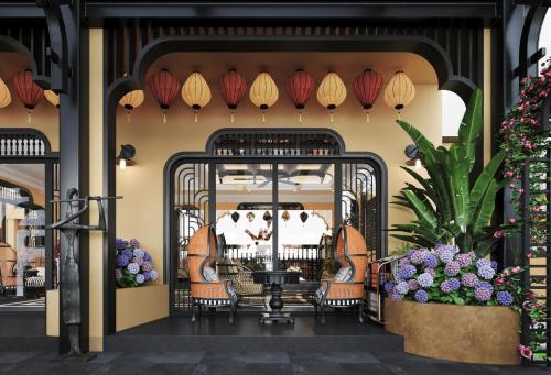 an entrance to a restaurant with chairs and umbrellas at L'Heritage Riverside Hoi An in Hoi An