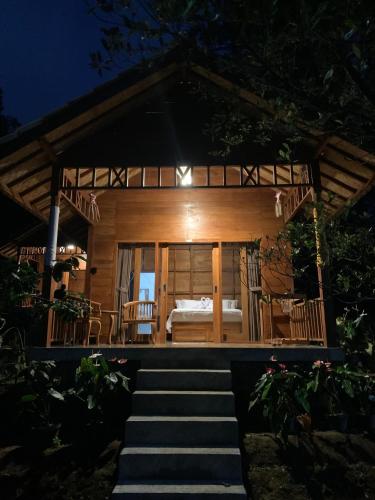 Una casa de huéspedes por la noche con una cama en Kubu Waru Bali, en Munduk