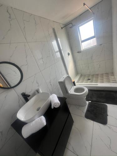 a white bathroom with a sink and a toilet at Grace Boutique Guest House in Manamakgoteng