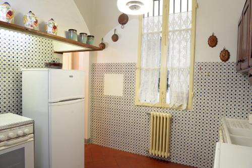 een keuken met een witte koelkast en een raam bij Palazzetto dei Nobili Apartment in Florence