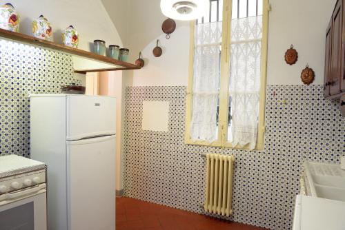 kuchnia z białą lodówką i oknem w obiekcie Palazzetto dei Nobili Apartment we Florencji