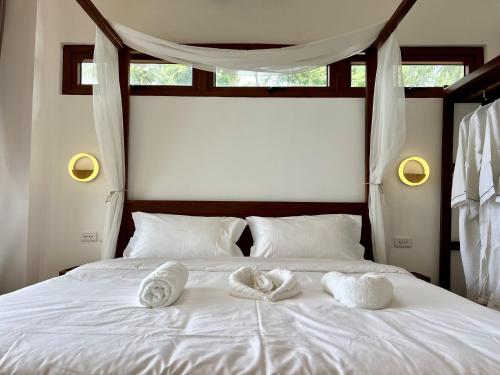 a white bed with towels on it with a window at Resort Deja Vu in Siquijor