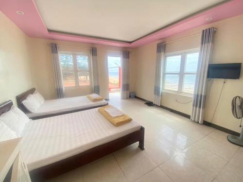 a large room with two beds and a tv at Hải Yến Hotel in Dong Hoi