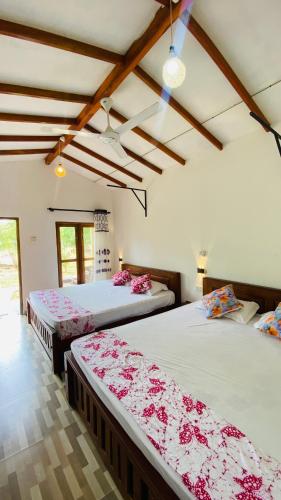 a room with two beds in a room at River paradise safari house with cooking class in Udawalawe