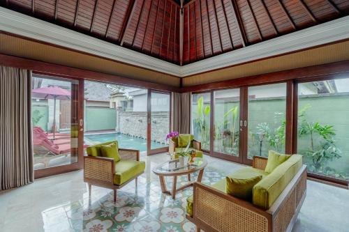 a living room with chairs and a table at Arkamara Dijiwa Ubud in Ubud