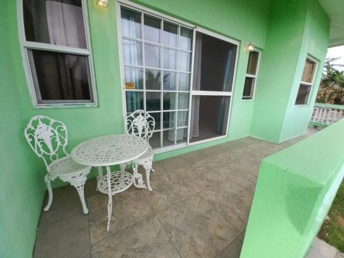 a patio with a table and chairs on a green house at Nested View in Westerhall Land Settlement