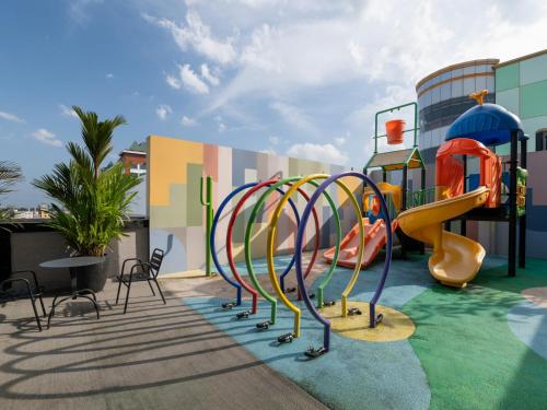 a playground at a resort with a slide at Grand Zuri Pekanbaru in Pekanbaru