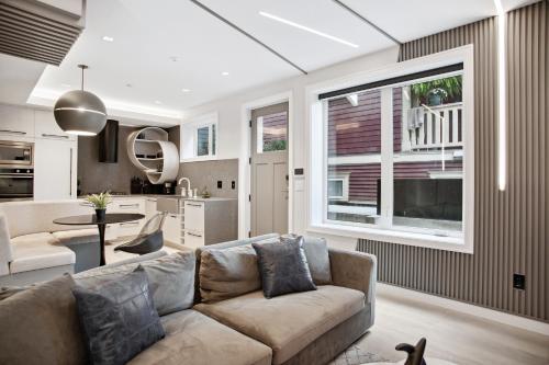 a living room with a couch and a kitchen at Designer 2BR in Downtown Steps from Sunset Beach in Vancouver