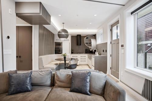 a living room with a couch and a kitchen at Designer 2BR in Downtown Steps from Sunset Beach in Vancouver