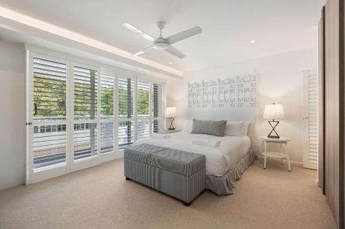 ヌーサヘッズにあるLa Mer Apartmentsの白いベッドルーム(ベッド1台、大きな窓付)