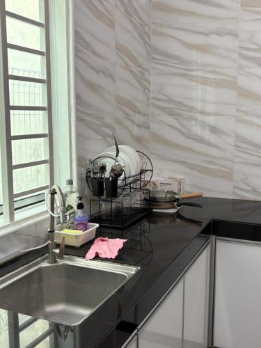 a kitchen with a sink and a counter top at Lock homestay in Kulai