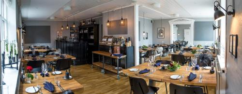 a restaurant with wooden tables and chairs in a room at Refborg Hotel in Billund