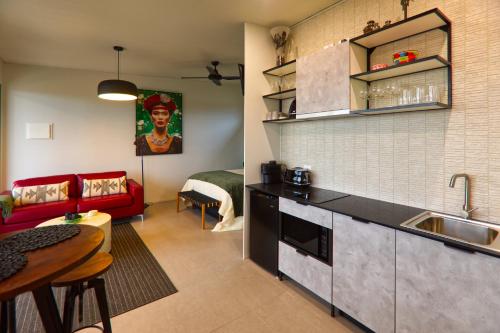 a kitchen and living room with a red couch at The Rusty Kangaroo - Spectacular Ocean View Couples Boutique Studio in Penneshaw