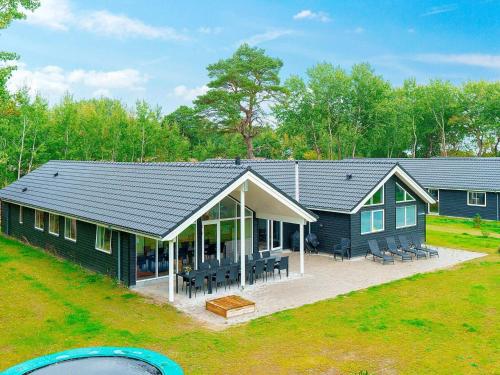 an overhead view of a blue house with a patio at 18 person holiday home in Væggerløse in Marielyst