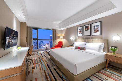 a bedroom with a large white bed and a desk at Chengdu Yueming Hotel,2-minute walk to Zhongba Subway ,close to Kuanzhai Alley and Chunxi Road,Free laundry, Free coffee, Chengdu food,English communication well,Private travel advice in Chengdu